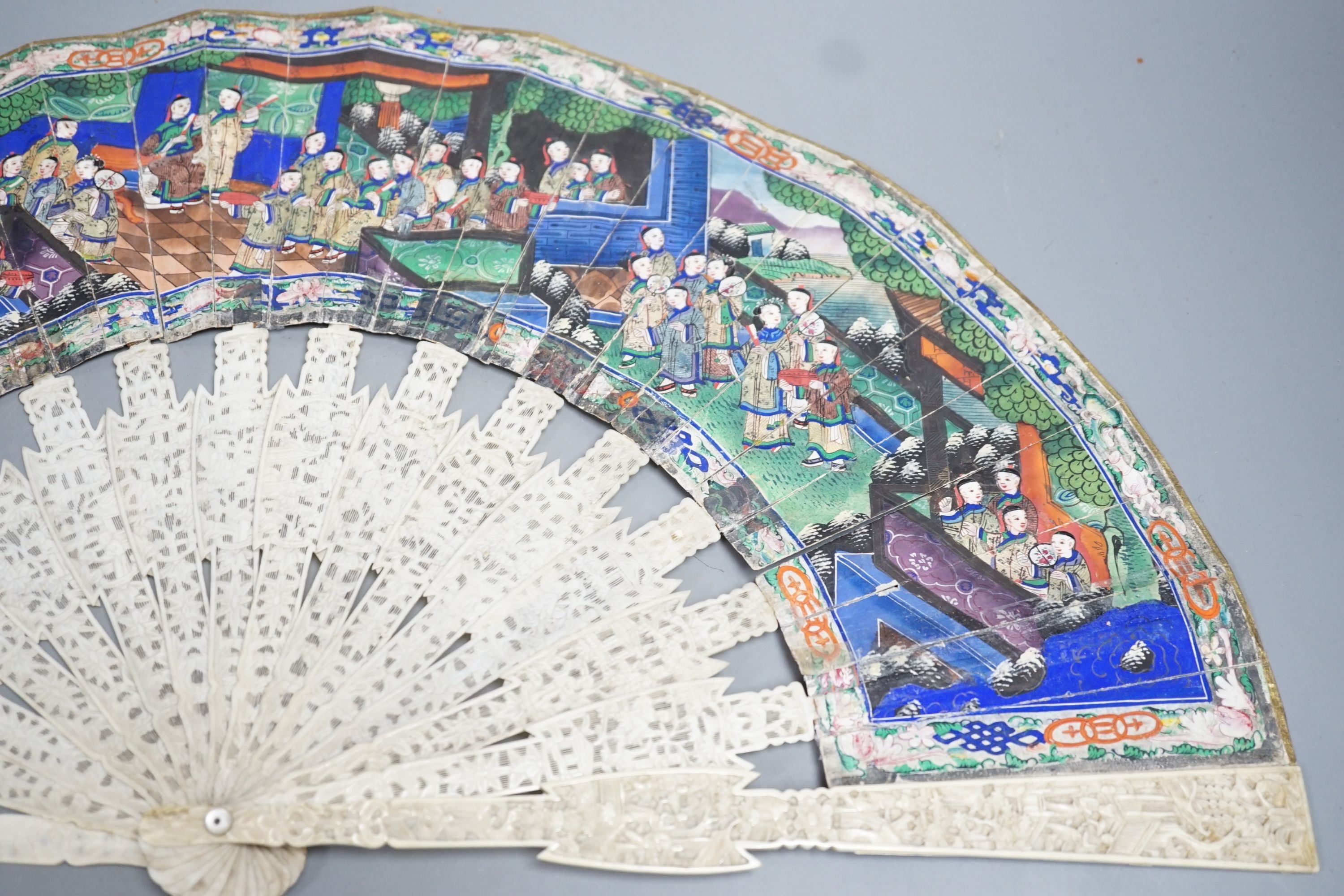 A 19th century Chinese export pierced ivory and painted paper leaf fan, in box. Fan 28cm long